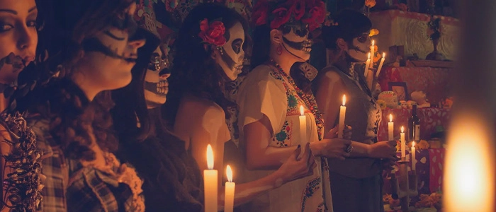 Mexicanos celebrando una de sus tradiciones emblemáticas, el día de los muertos.