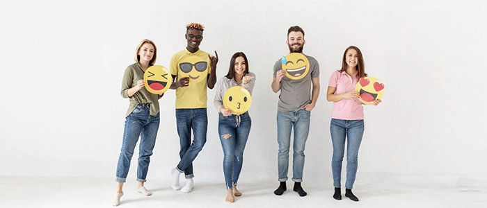 cinco personas de pie sosteniendo emoticones amarillos