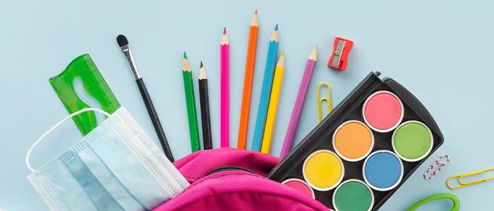 Diferentes tipos de útiles escolares dentro de una mochila color rosada