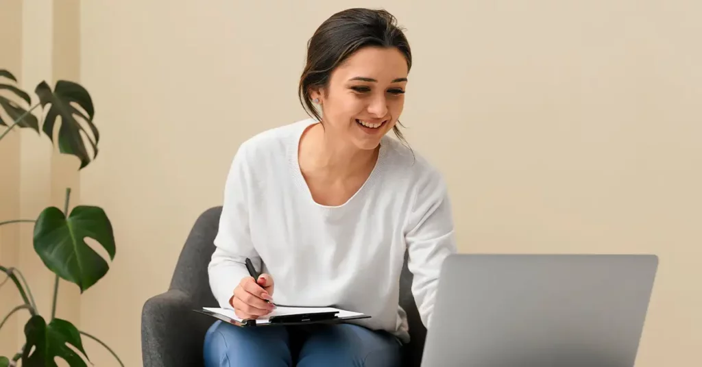 Mujer tomando notas de un computador portátil
