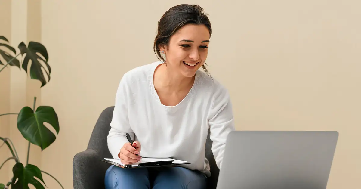 Mujer tomando notas de un computador portátil