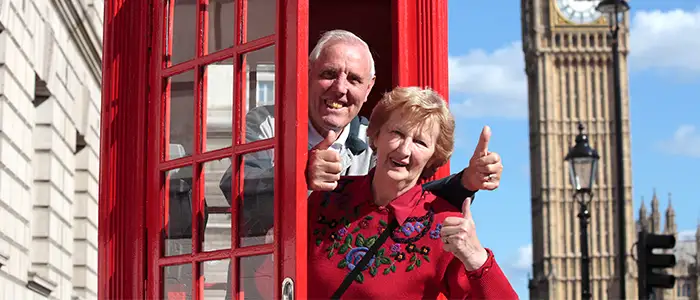 Pareja de un hombre y una mujer mayor en una cabina de teléfono roja en Londres