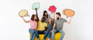 Amigos sonriendo y estudiando sinónimos y antónimos mientras sostienen una burbuja de chat