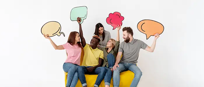Amigos sonriendo y estudiando sinónimos y antónimos mientras sostienen una burbuja de chat
